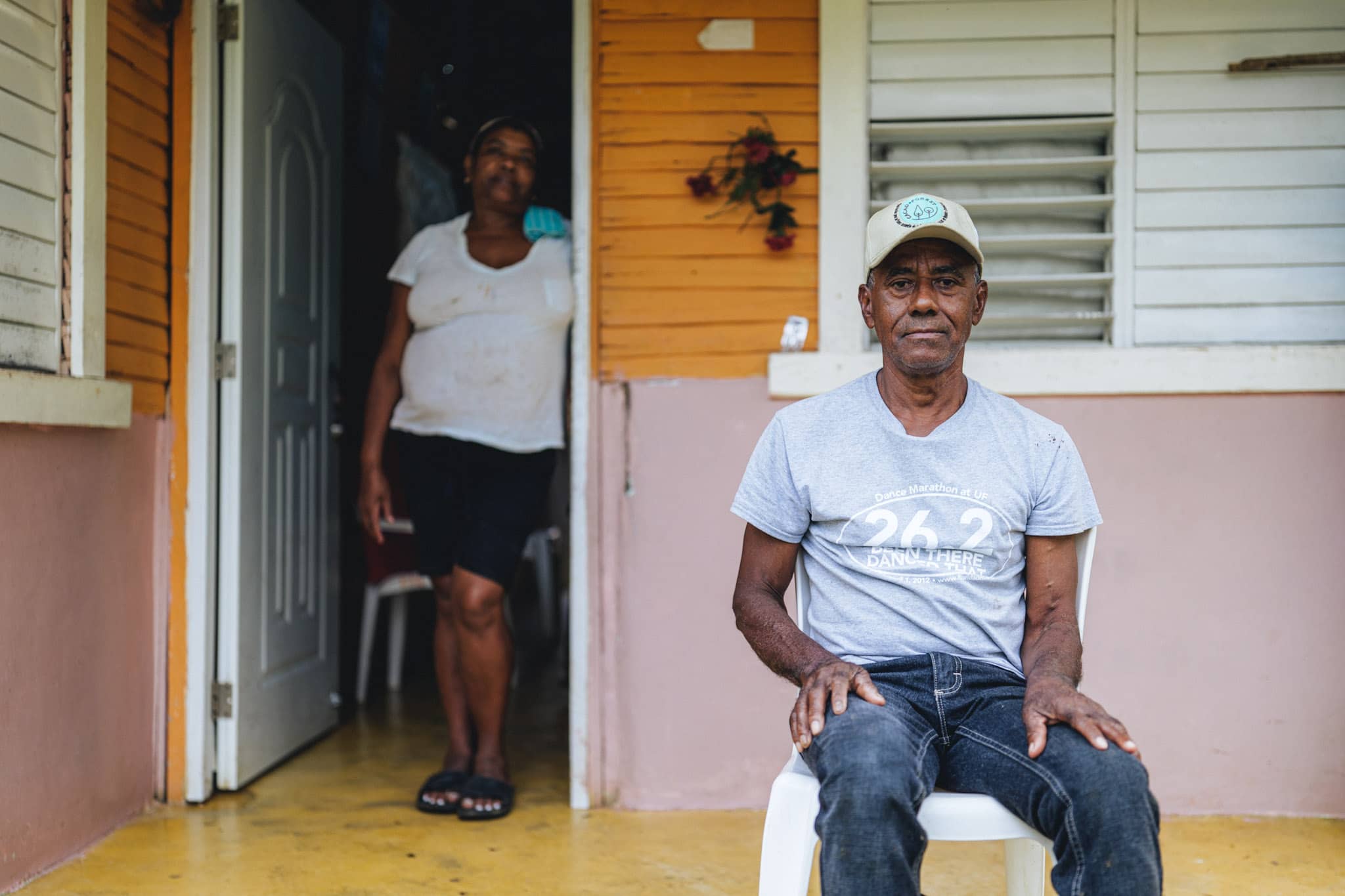 dominican cocoa producer sitting in front of his house