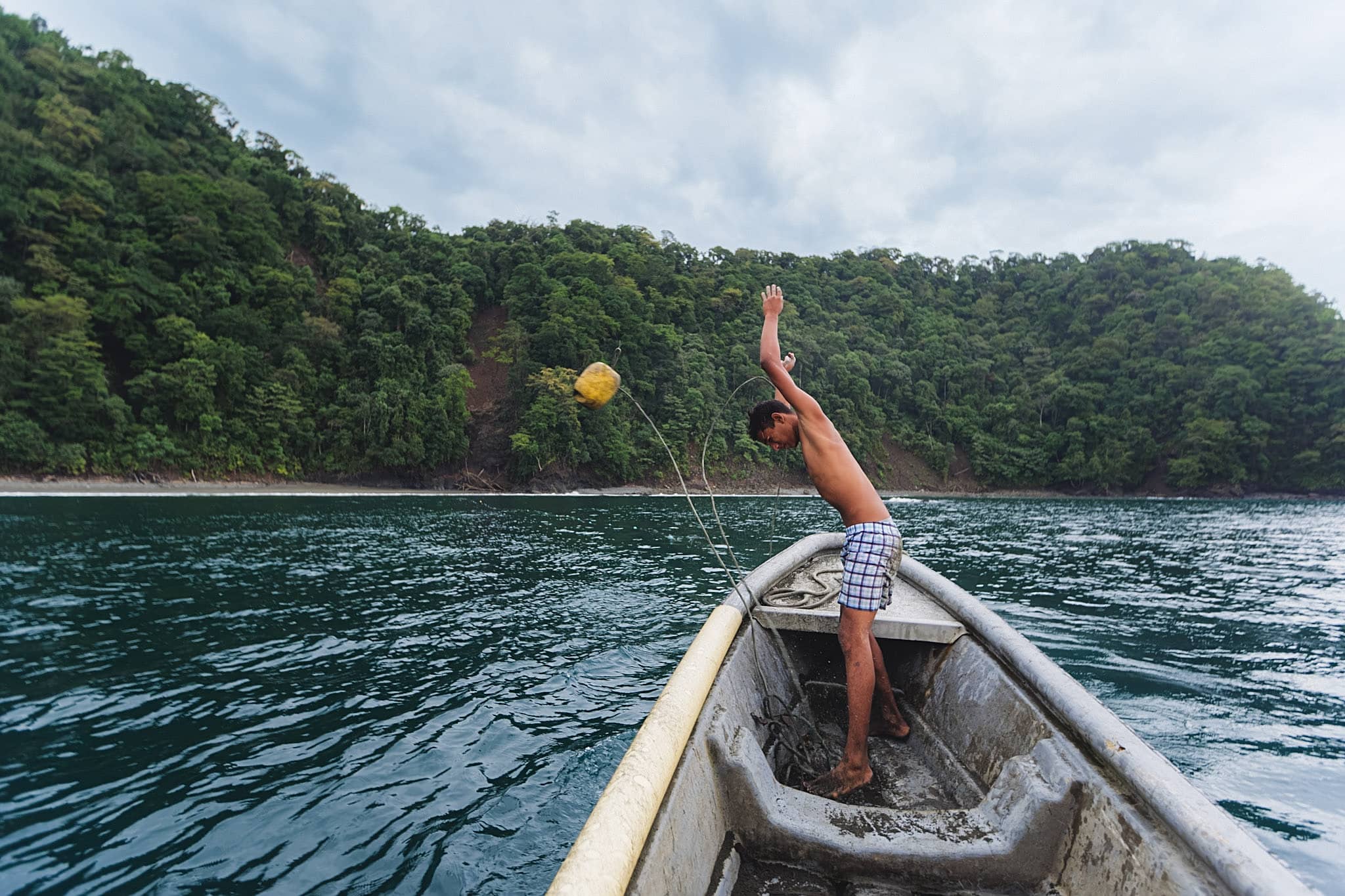 colombian fisherman throwing a buoy to make his net’s location in the chocó